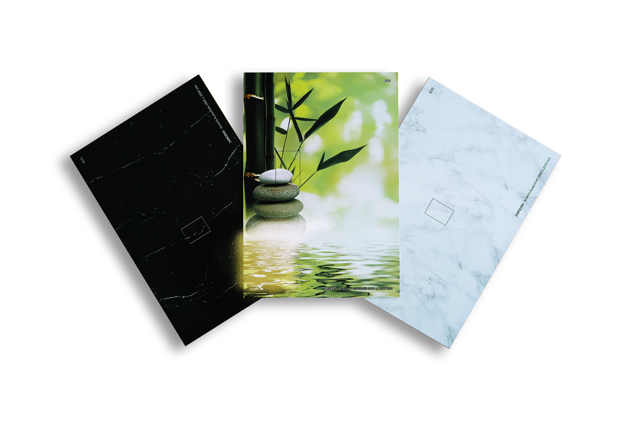 Drei Notizbücher mit unterschiedlichen Designs: Schwarz mit Marmor-Effekt, Zen-Motiv mit Steinen und Bambus sowie weißer Marmor-Optik.